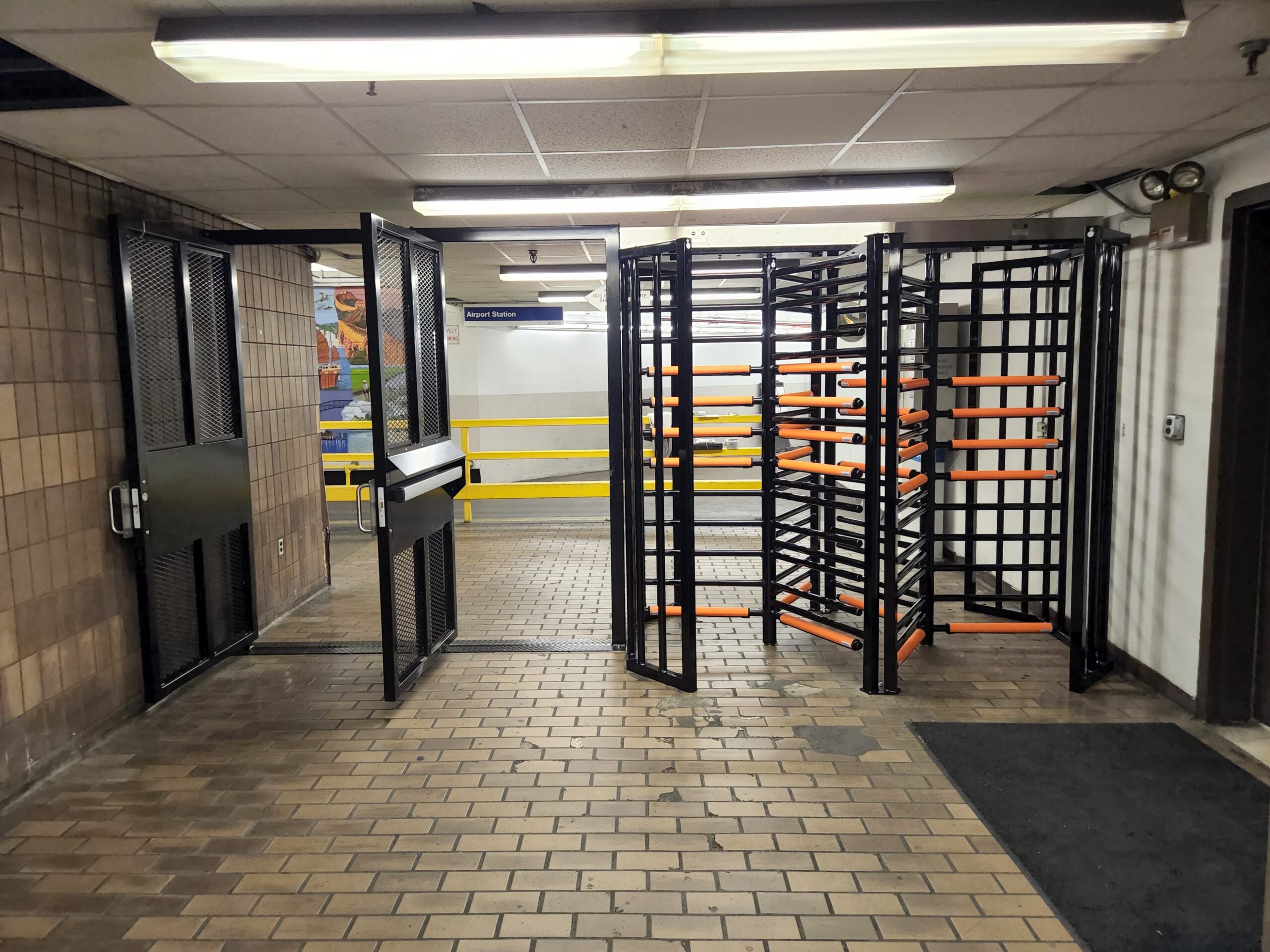 1 tandem full height turnstile and 2 full height ADA gates in a hallway at JFK international airport