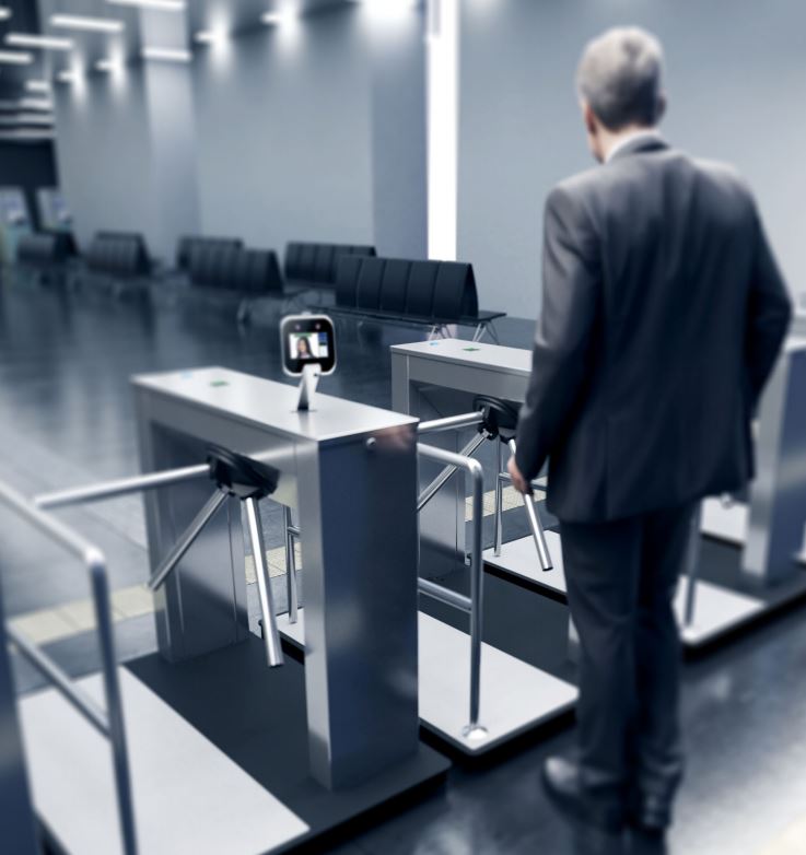 a man going through a turnstile equipped with a temperature sensor access control devise