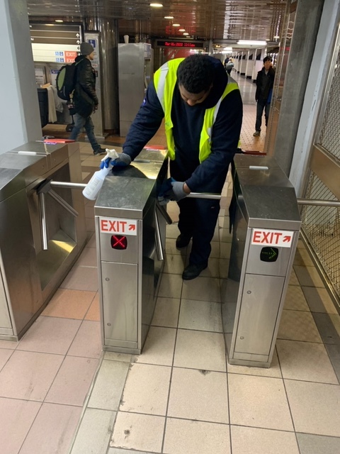 septa worker cleaning a turnstile with bleach 