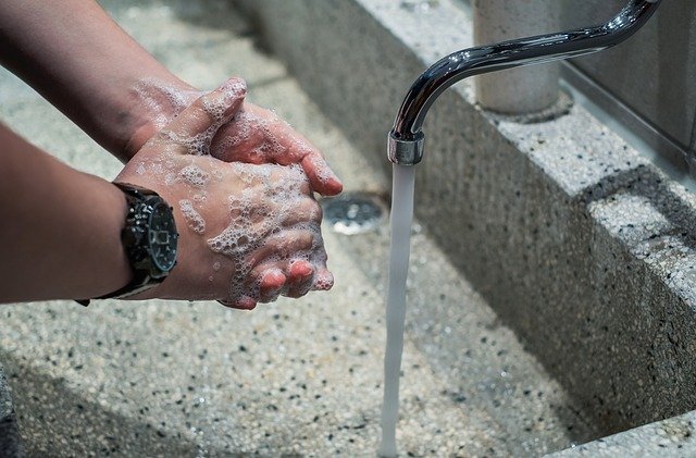person washing his hands with a black watch on