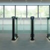 row of optical turnstile swinging glass barrier lanes in an office building