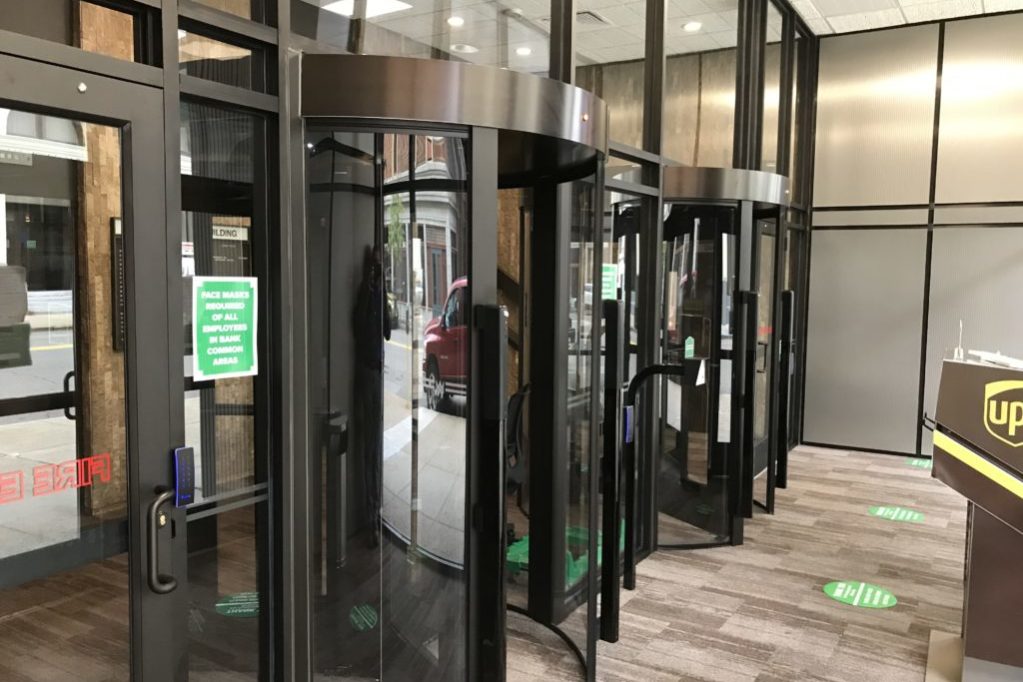 revolving door turnstile at the entrance to an office building in dark bronze