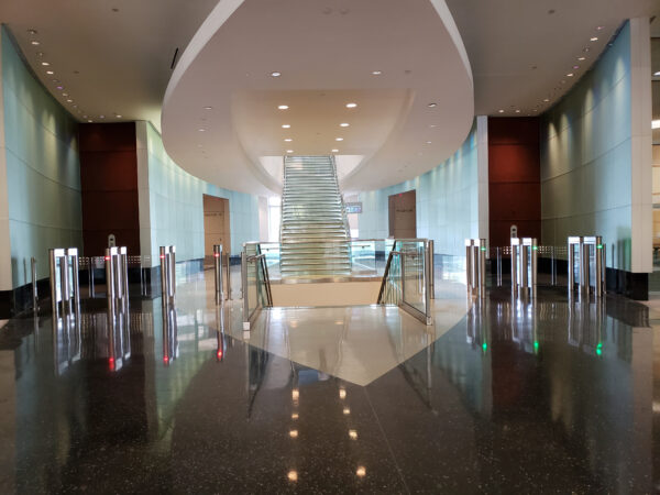 swinging barrier optical turnstiles at an office entrance with red and green indicator lights