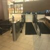 An MR200 ADA turnstile with optical glass barriers, installed in a sleek, modern space with clean lines and minimal decor.