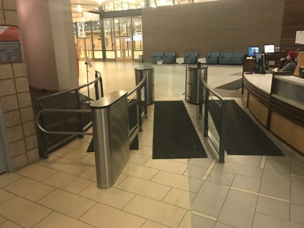 An MR200 ADA turnstile with optical glass barriers, installed in a sleek, modern space with clean lines and minimal decor.