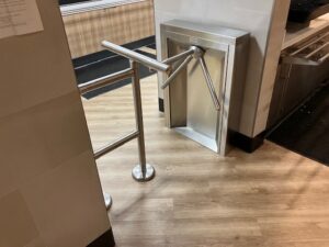 waist high turnstile in cafeteria blocking off the area so only authorized personnel can enter. Closed off with a railing and t-bar.