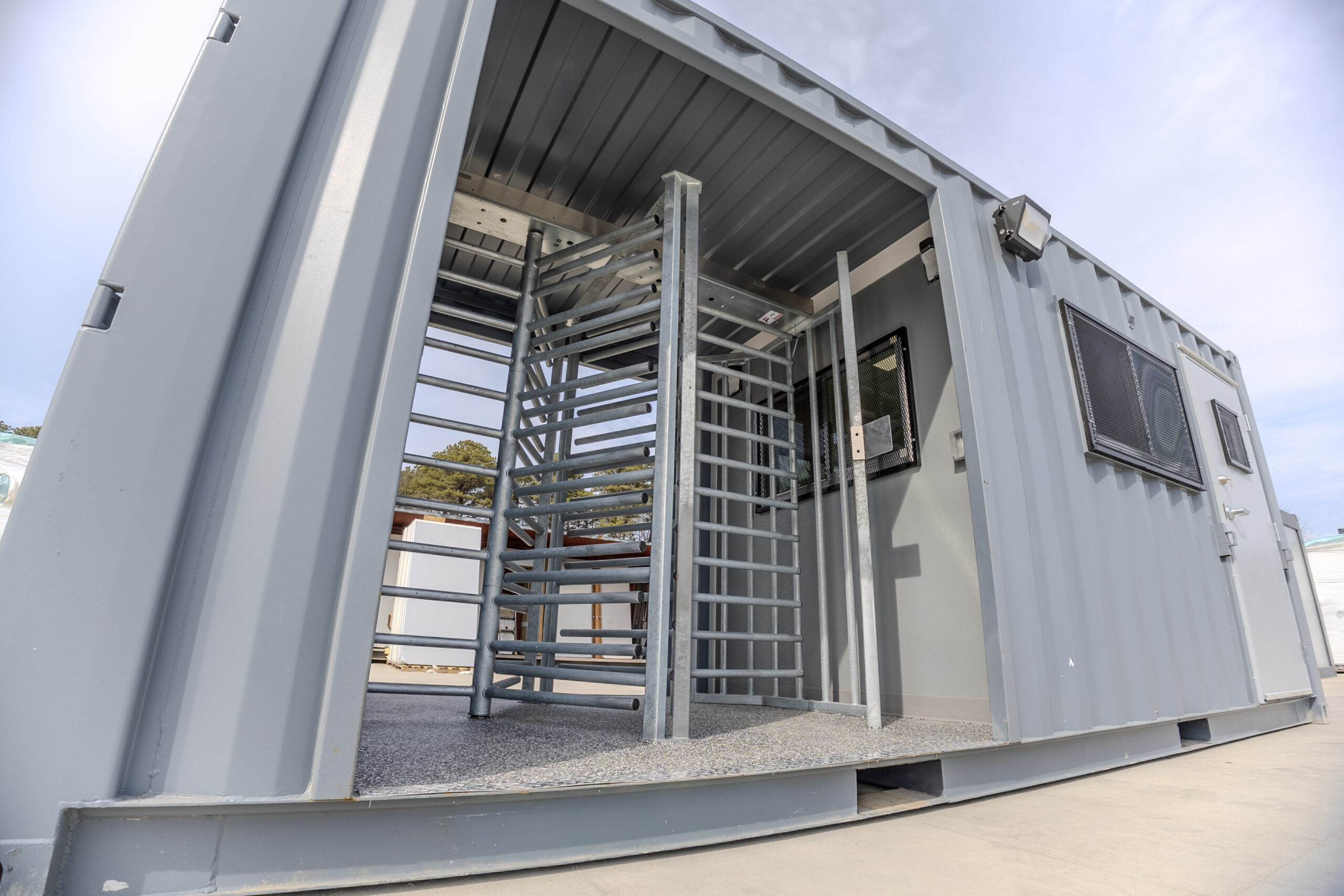 American made full height turnstiles installed inside a custom shipping container checkpoint